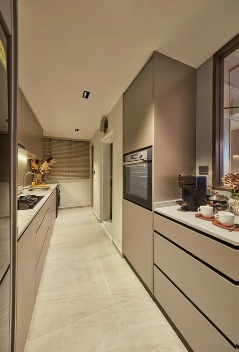 Galley kitchen of a Signature Collection home at Terra Hill, with warm-toned cabinets and built-in appliances (show unit photograph, for illustration only)